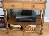 Front view of the washstand showing two drawers, lower shelf with some items on and below it.