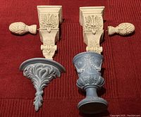 Blue vase and matching wall shelf with white decorative drapery rod wall brackets and finials on red background.