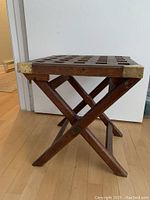 Side view showing folding X-frame leg structure and brass corner plate at top corner.