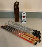 Lot contents showing tall wooden matches holder with oversized matches, medium stained glass matches holder with floral design, four metal skewers with wooden handles, four extending forks with black handles