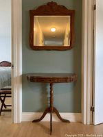 Full view of half-round hall table and matching mirror installed on wall