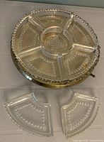 Top view of Lazy Susan showing brass base and clear glass sections, two glass sections placed separately in front.