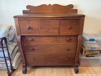 Front view of chest showing three drawers and decorative backboard