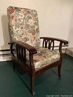 Front view of wooden reclining chair with floral upholstered cushions on seat and backrest.