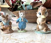 All three Beswick figurines displayed together on a marble surface: Old Mr Bouncer mouse, Tom Kitten cat, and Dinkum platypus.
