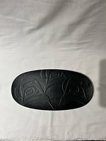 Top view of the black recycled glass serving platter with a carved Killer Whale design.