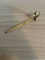 Full view of the brass duck head letter opener showing the duck head handle and the blade with engraving.