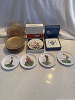 Front view of all coasters showing Gold Leaf Pier One, Pimpernel floral, Asian styled, and golf melamine coasters