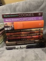 Cookbooks stacked showing spines with titles and authors by William Sonoma and Martha Stewart