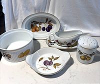 Full set of Evesham Gold Royal Worcester porcelain including gravy dish, tray, flour shaker, oval serving dish, and small dish shown on white surface.