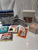 Photo of all the games and puzzle items arranged together showing boxes and packs