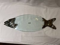 Top view of oval glass serving platter, showing silver-plated fish head and tail.