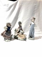 All three Lladro porcelain figures together: girl with basket, girl feeding lamb, boy in overalls