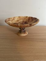Front side shot of the pedestal bowl showing the scalloped edges and marbled alabaster colors.