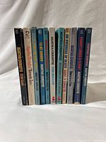 Side view of 11 vintage Agatha Christie paperback books showing titles and wear