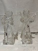 Front view of both vintage Mikasa lead crystal angels, one playing violin and the other mandolin, standing side by side.