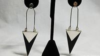 Frontal view of the pair of silver and black onyx arrow drop earrings.