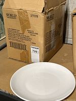 Photo of the cardboard box packaging showing brand, model name Porcelana, plate size 11 1/4 inches, quantity 1 dozen.