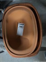 Photo of the inside of one clay roast baking pan showing light use marks and oval shape.