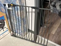 Full view of metal door gate standing upright showing vertical bars and overall size.
