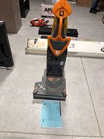 Front view of upright floor cleaner with loose manual at base