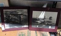 Two mounted black and white historical photos on plaques showing Kingston waterfront scenes including boats, piers, and historical vehicles.