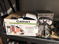 Packaged Cuisinart 15-piece blending and chopping system box alongside the Prime Gourmet kettle on a shelf.