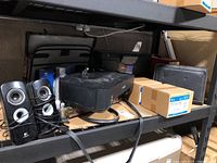 View showing Canon iP2700 printer front, USB cable, Oscar de la Renta briefcase and other items on shelving