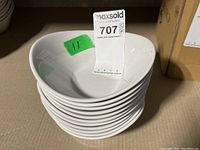 Stack of 11 white small bowls showing smooth and glossy finish, minimal marks from storage.