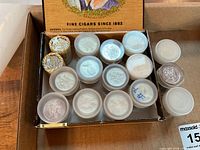 Box showing two sealed paper rolls and 16 small plastic coin containers