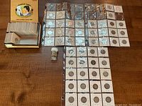 Overview of 119 silver quarters in individual flips and sheets with cigar box on left
