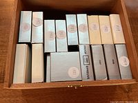 Wooden box with multiple labeled coin presentation cases