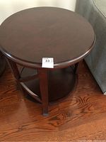 Top view of the round wooden end table showing smooth surface and round edge