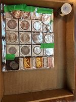 Overview of tube and assorted coins and bars in cardboard flips
