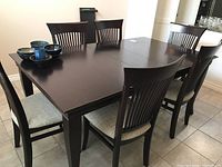 Full view of dark brown dining table with six chairs