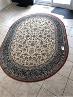 Full view of oval rug laid on tile floor showing overall design and size