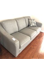 Angled left view showing overall shape, arms, and seat cushions