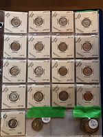 Twenty US silver coins (dimes, quarters, half dollars) in cardboard flips arranged in binder page.