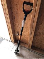 Full view of the Fiskars extendable weeding tool showing the handle, midsection, and claw base.