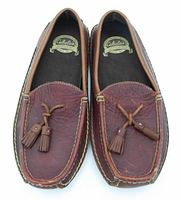 Top view of pair of brown leather Cabela's slippers with tassel details on the front and stitched trim.