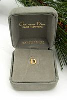 Tie tack inside original gray Christian Dior box showing branding and presentation.