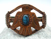 Front view of copper bracelet showing Thunderbird with oval turquoise stone centerpiece and detailed etchings.