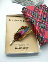 Feather plume kilt pin in original box with tartan lid and card stating origin from Kiltmaker, Inverness.