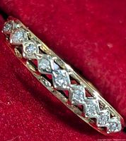 Close-up of the front view of the yellow gold ring showing the diamond settings and lattice design.