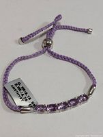 Front view of adjustable bracelet showing the amethyst stones and braided cord.