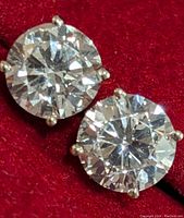 Front view of both round stones in prong settings on red background