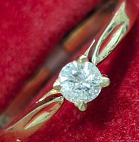 Close-up front view of the yellow gold ring showcasing the round-cut diamond and polished band with subtle design details.