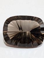 Top-down view of cushion-cut smokey quartz showing complex concave facet pattern on crown