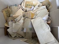 Large plastic bin filled with hundreds of vintage stamps stored in envelopes and sleeves