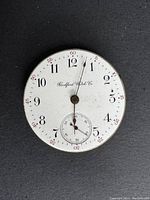Front view of vintage Rockford pocket watch white enamel dial with black hour numerals and red outer minute markings.